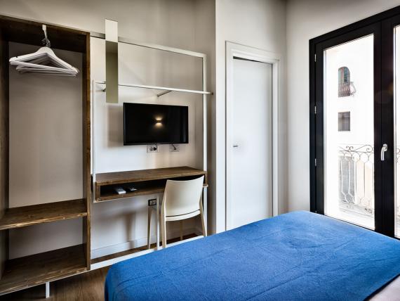 Camera del Teku Boutique Hotel con letto blu, scrivania e finestre sul balcone
