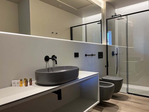 Bagno moderno della Evangelisti Palace Suite & Apartaments con lavabo grigio.