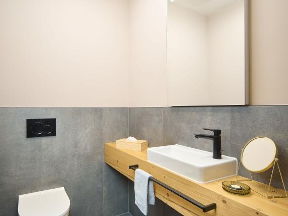 Modernes Badezimmer im Hochfeldhof mit Holzablage, Spiegel und grauen Fliesen