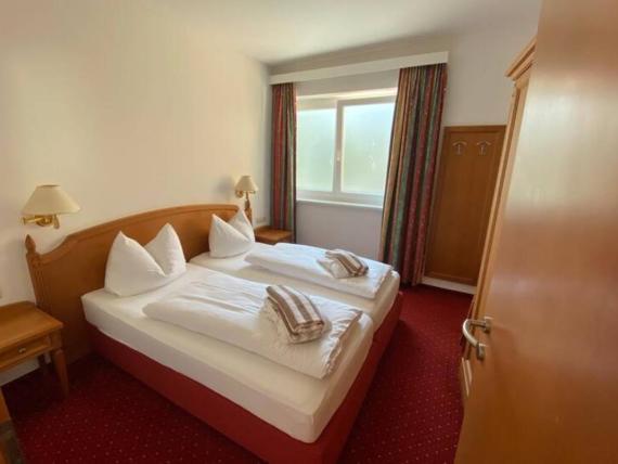 Gemütliches Doppelzimmer im Hotel Moarhof mit Holzmöbeln und rotem Teppich