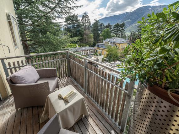 Balkon mit Stühlen im Hotel Mignon Meran Park & Spa mit Bergblick