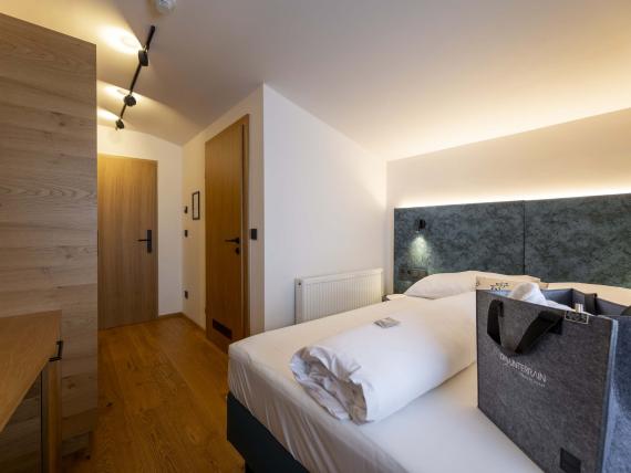 Camera d'hotel moderna al Das Unterrain Lifestyle Hotel con mobili in legno e illuminazione calda