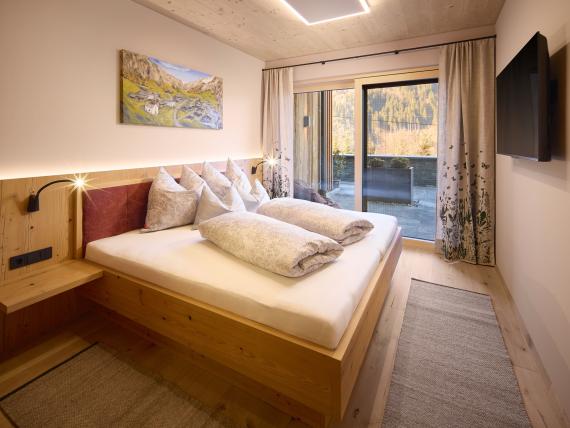 Gemütliches Schlafzimmer mit Holzmöbeln im Hochfeldhof mit Terrasse und Bergblick