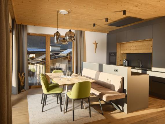 Essbereich mit grünen Stühlen und Küche im Hochfeldhof