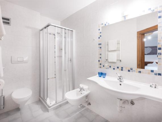 Modernes Badezimmer im Parc Hotel Florian mit Fensterblick und Pflanzen