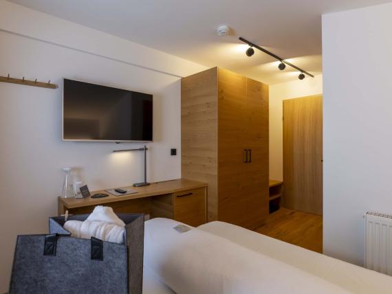 Camera moderna al Das Unterrain Lifestyle Hotel con TV e mobili in legno