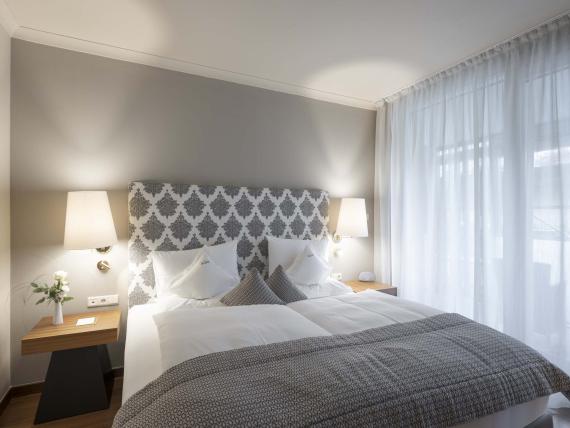 Modernes Doppelzimmer im Hotel Mignon Meran Park & Spa mit hellen Vorhängen