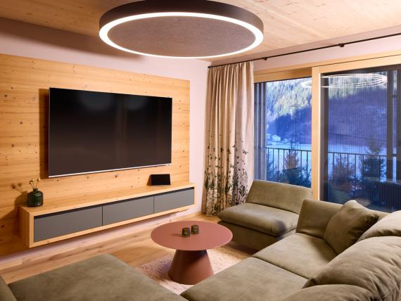 Wohnzimmer im Hochfeldhof mit Sofa, TV und Balkon mit Bergblick
