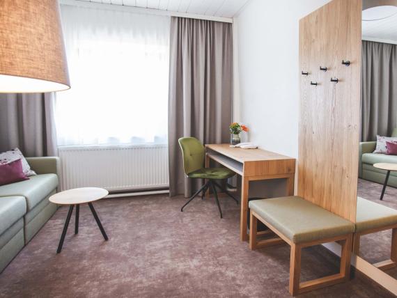 Der Dolomitenhof ***S gemütliches Wohnzimmer mit Sofa und Schreibtisch