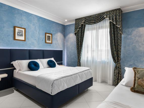 Camera elegante con decorazioni blu all'Hotel Regina Caserta