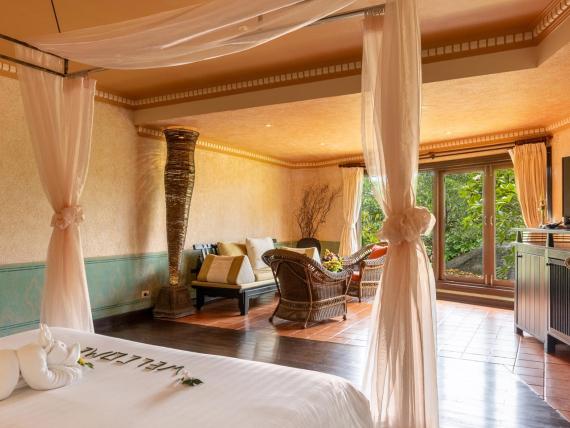 Cozy room with seating and beds at The Mangosteen Ayurveda & Wellness Resort