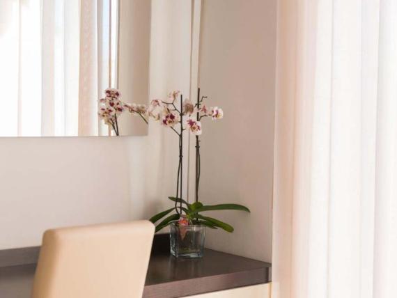 Hotel Viola Gaeta tavolo con orchidea e sedia davanti alla tenda