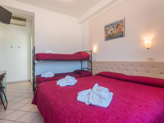 Camera con letti rossi decorati con fiori di asciugamani