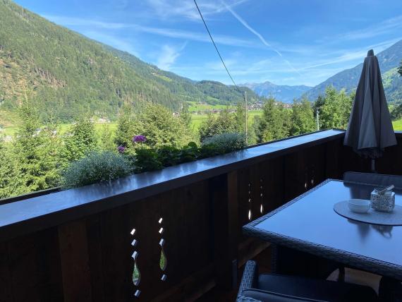Balkon mit Tisch und Stühlen mit Blick auf Berge und Tal bei Hochfeldhof