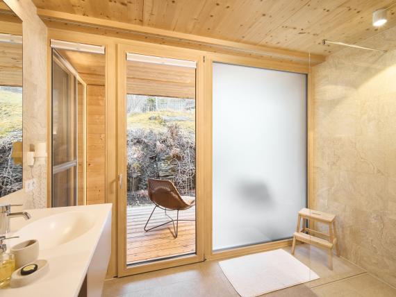 Helles Badezimmer mit Glasfenstern und Stuhl im Hochfeldhof