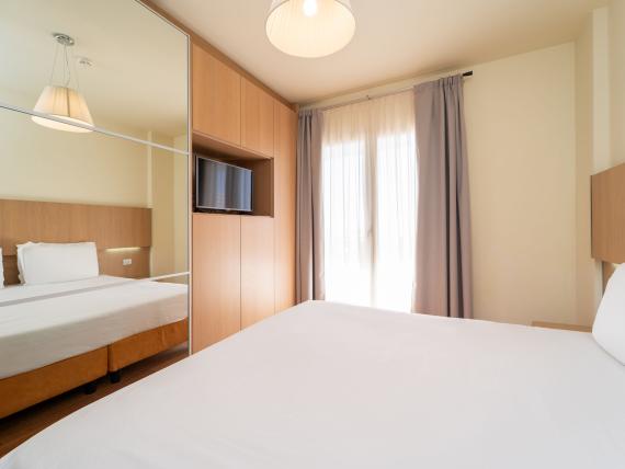 Camera da letto con letto matrimoniale e armadio al Bibione Palace Hotel