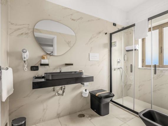 Bagno moderno al Reggia Suite Spa Hotel con doccia e lavabo grigio