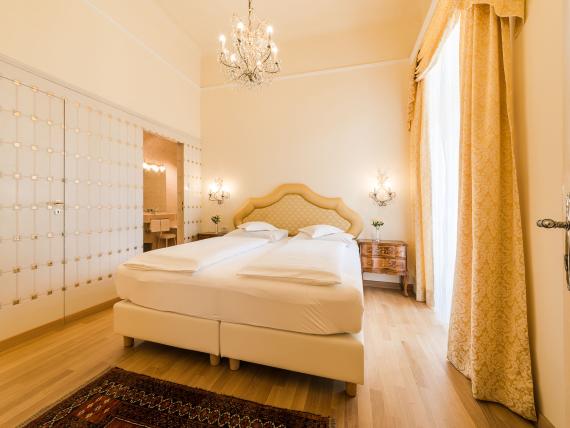 Elegant bedroom at Hotel Adria with double bed and antique furniture