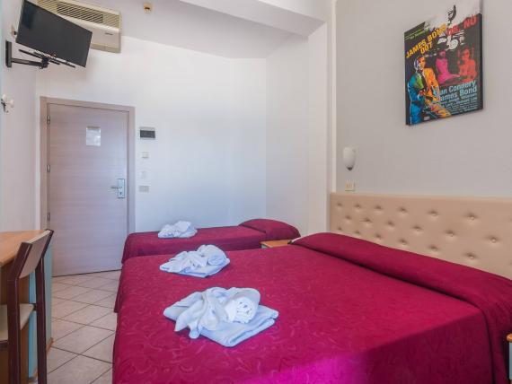 Camera d'albergo con due letti e decorazioni di fiori sugli asciugamani