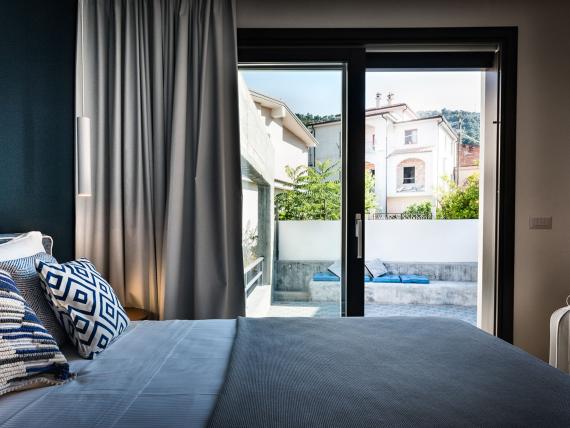 Camera con letto e porte vetrate aperte al Teku Boutique Hotel