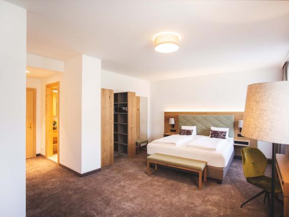 Helles Doppelzimmer im Der Dolomitenhof ***S mit modernen Möbeln und Teppichboden