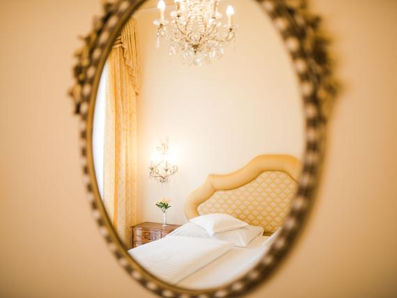 Mirror reflection of an elegant hotel room at Hotel Adria with stylish headboard