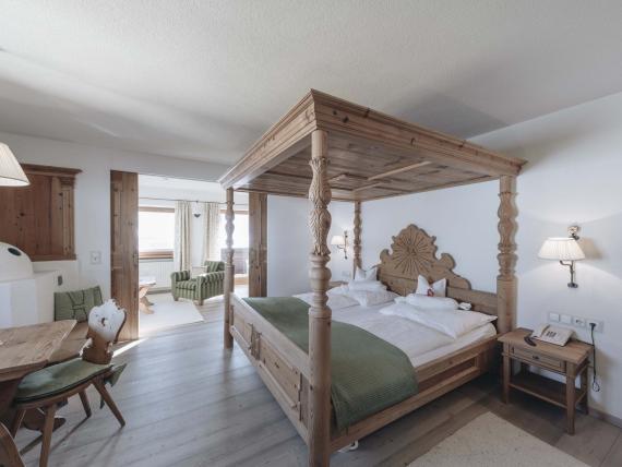 Gemütliches Hotelzimmer mit Holzbett und dekorativem Baldachin bei DER GREIL