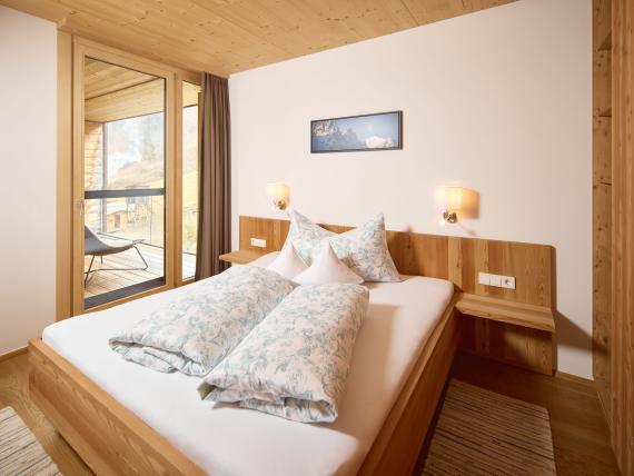 Gemütliches Schlafzimmer im Hochfeldhof mit Holzmöbeln und Balkon