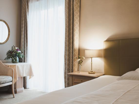 Bright, cozy room at Hotel Adria with bed, lamp, and seating area