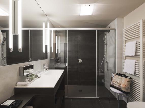 Modernes Badezimmer im Hotel Mignon Meran Park & Spa mit Dusche und Waschbecken
