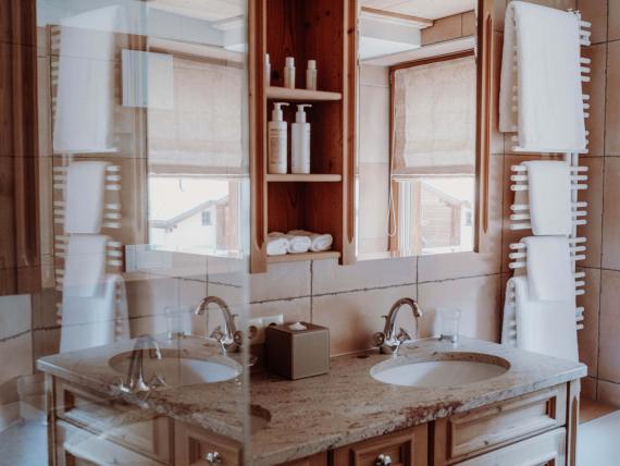 Badezimmer mit zwei Waschbecken und Holzschrank im Das Verwall Lech