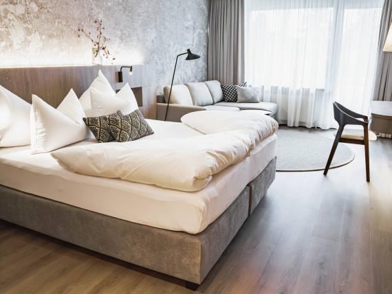 Krumers Alpin hotel room with beds, sofa, and desk in modern style