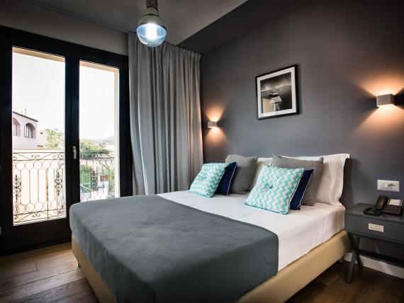Camera del Teku Boutique Hotel con letto, scrivania, TV e armadio a vista