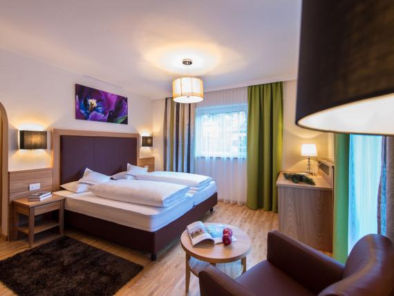 Modernes Doppelzimmer im Parc Hotel Florian mit gemütlichen Betten und Sitzbereich