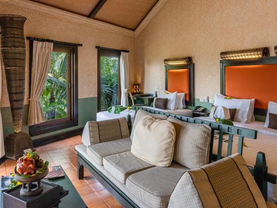 Room with double bed and sofa at The Mangosteen Ayurveda & Wellness Resort