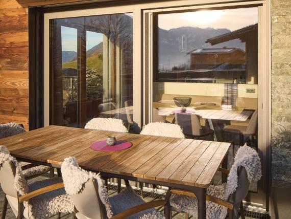Terrasse mit Holztisch und Stühlen beim Hochfeldhof mit Bergblick
