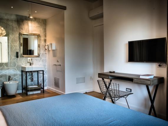 Camera del Teku Boutique Hotel con letto blu, bagno a vista e scrivania