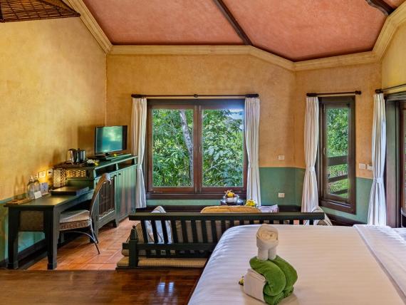Cozy room at The Mangosteen Ayurveda & Wellness Resort with bed and seating area