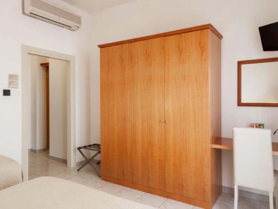Camera dell'Hotel Viola Gaeta con armadio in legno, scrivania e televisore