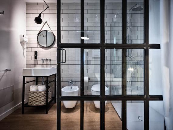 Bagno moderno con parete vetrata e piastrelle al Teku Boutique Hotel