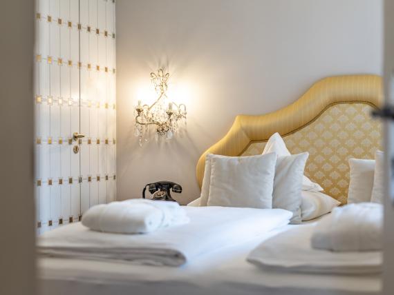 View of elegant Hotel Adria room with yellow headboard and fresh towels
