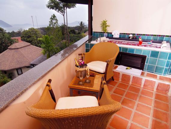 Balcony with chairs and jacuzzi at The Mangosteen Ayurveda & Wellness Resort with forest views