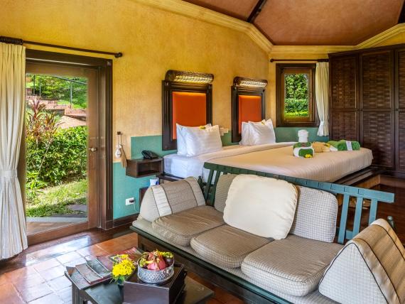 Spacious room with bed and sitting area at The Mangosteen Ayurveda & Wellness Resort