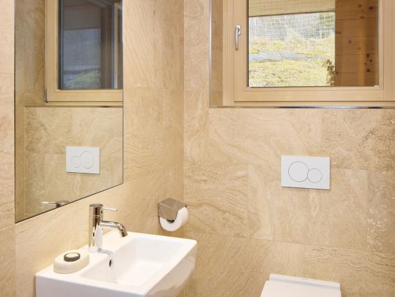 Helles Badezimmer mit Wandtoilette und Waschbecken im Hochfeldhof