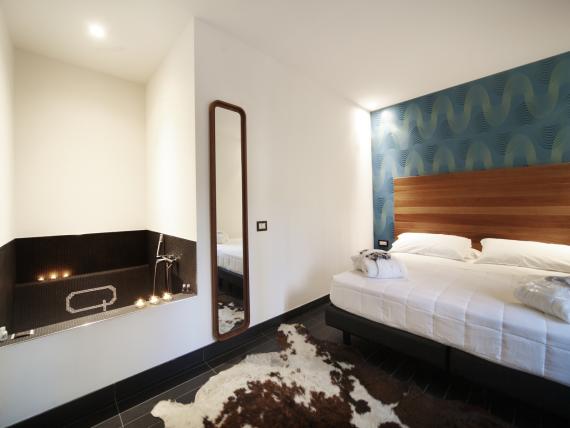 Camera d'albergo moderna al Q Hotel con vasca, specchio e letto comodo