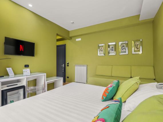 Camera luminosa con TV e divano al Reggia Suite Spa Hotel