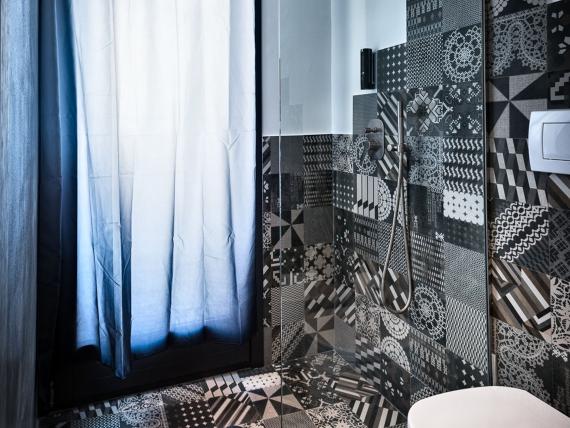 Bagno del Teku Boutique Hotel con piastrelle geometriche, doccia e WC