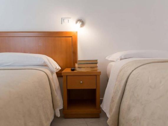 Camera con due letti singoli e comodino all'Hotel Viola Gaeta