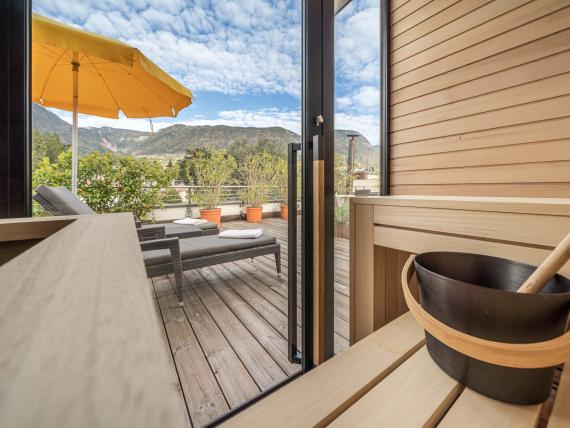 Sauna und Terrasse mit Liegestühlen und Bergblick im Hotel Mignon Meran Park & Spa