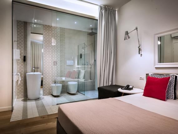 Camera moderna con letto matrimoniale e bagno vetrato al Teku Boutique Hotel